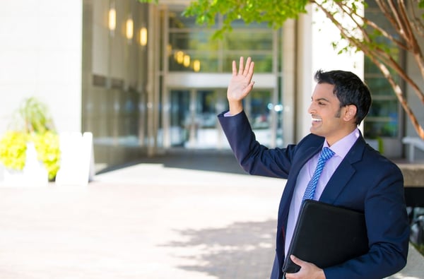 man smiling as he leaves the office early